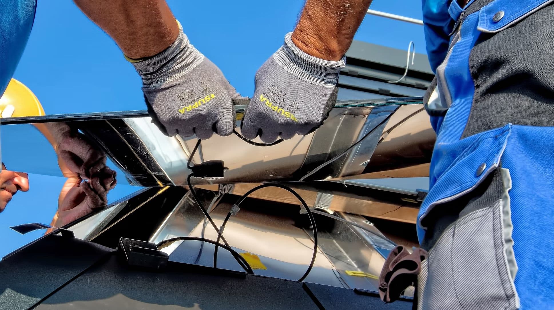 Hands working on a solar panel
